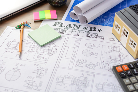 Drawings, layout of the house, documents, calculator on the desktop in the office. Engineering,...