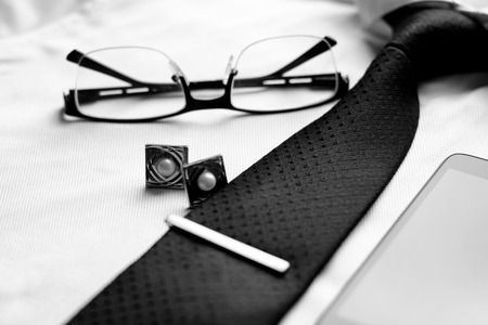 Business accessories (cufflinks, fountain pen, tablet, phone, glasses, notepad, tablet) at the men's...