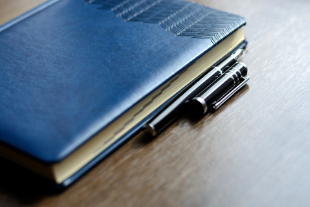 Business accessories on desktop: notebook, diary, fountain pen. Macro with blur and soft focusの写真素材