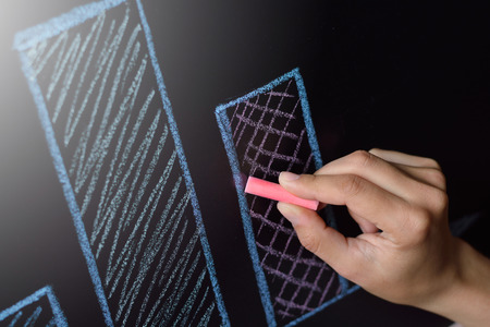 Business woman drawing colored chalk on a blackboard charts, plans, diagramsの写真素材
