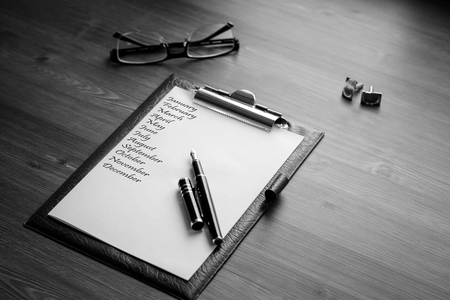 Title name of month and business accessories on desktop: notebook, diary, fountain pen, cufflinks, glasses.の写真素材