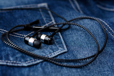 Headphones, mobile phone, tablet on pocket of jeans. Macro with blur and soft focus.の写真素材