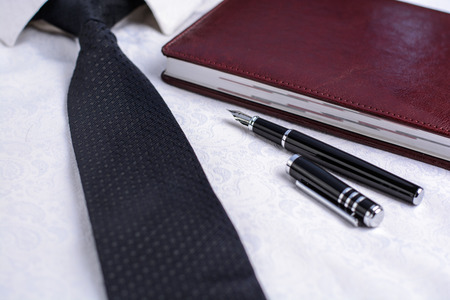 Business accessories (cufflinks, fountain pen) in the men's classic white shirt with tieの写真素材