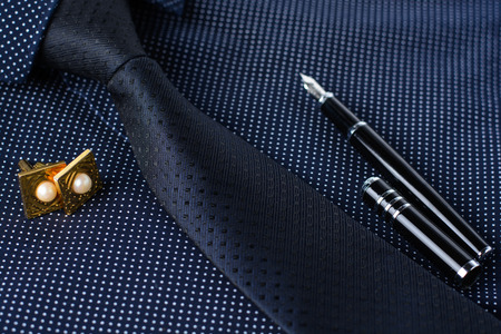 Business accessories (cufflinks, fountain pen, tablet, phone, notepad, dairy) in the men's classic shirt with tieの写真素材