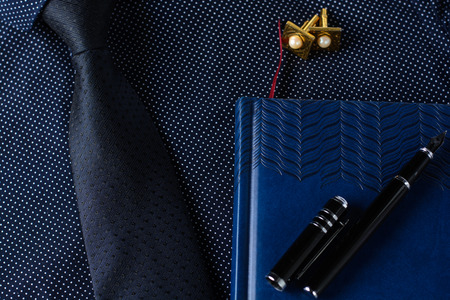 Business accessories (cufflinks, fountain pen, tablet, phone, notepad, dairy) in the men's classic shirt with tieの写真素材