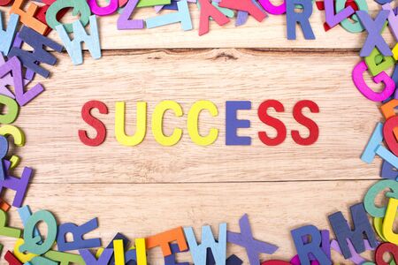 colorful wooden letter of the alphabet and the word SUCCESS isolated on wood backgroundの写真素材