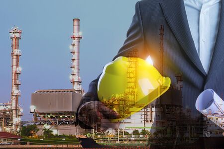 Double exposure of Business man with safety helmet and oil refinery industry plant backgroundの写真素材
