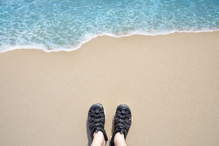 Summer holiday concept , top view selfie of feet in black sandals on beachの写真素材