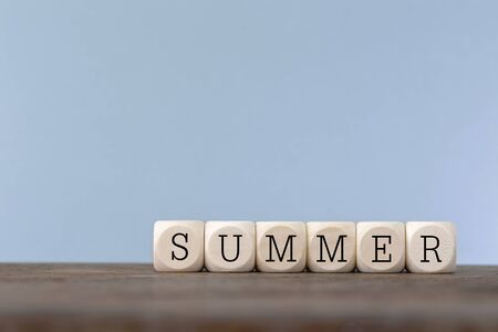 Summer word written in wooden cube on wooden tableの写真素材