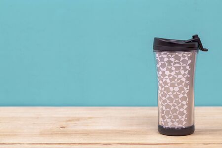plastic tumbler glasses or  travel cup  isolated on wooden backgroundの写真素材