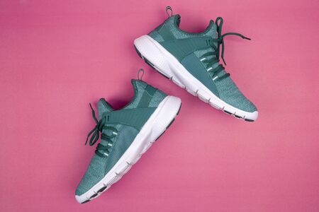 Green sneakers or sport running shoe isolated on a pink backgroundの写真素材