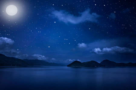 Mountain landscape view and Starry night sky with stars and moon in cloudscape backgroundの写真素材