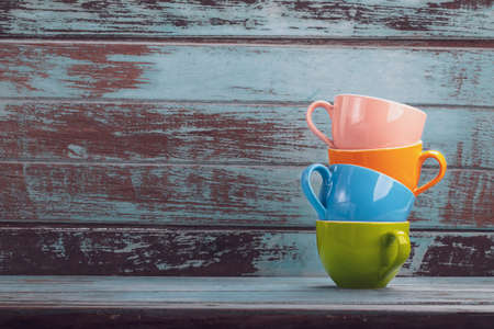 Vintage tone colorful coffee cups with copy space on wood board , stack coffee cupの写真素材