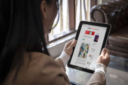 Closeup businesswoman reading news fashion or articles on website on the screen in smart taplet ,...