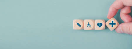 Hand chooses a emoticon icons healthcare medical symbol on wooden block , Healthcare and medical...