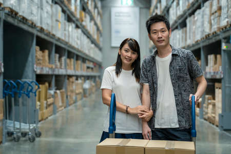 Portrait of young couple asian shopping new lifestyle of stock product inventory on shelf , logistic business shipping and delivery serviceの写真素材