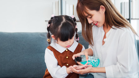 Asian mother and daughter washing hands with alcohol gel or antibacterial soap sanitizer at home , Mom teach child how to wash hands with sanitizer gel to avoid infections virus and bacteriaの写真素材