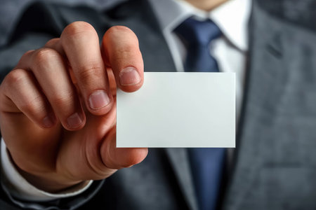 Businessman confidently displays a blank business card, emphasizing professionalism and success in a corporate settingの素材
