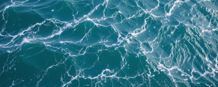 An ocean water surface with white foam patterns and waves creating dynamic and natural marine texture in deep blue colorの素材