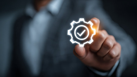 Successful quality control concept with businessman hand pointing gear icon with check mark symbol glowing in dark backgroundの素材