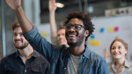 Smiling man raising hand in casual meeting, group of young adults in modern office, teamwork, learning, positive energyの素材