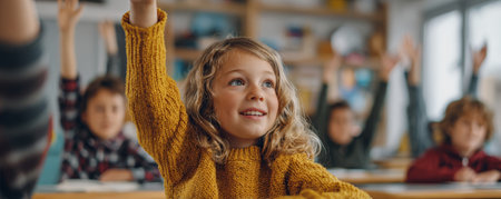 Curious schoolgirl raising hand eagerly in classroom with other children learning and participating activelyの素材