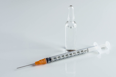 Injection syringe, needle with ampoule on white background.の写真素材