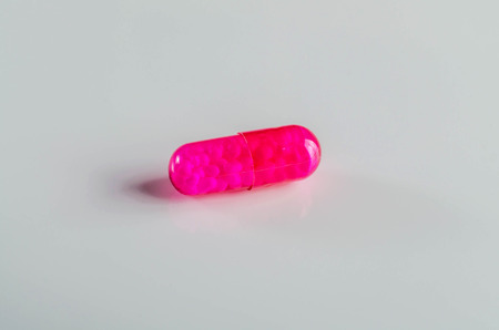 Single brightly colored capsule on a gray background.の写真素材
