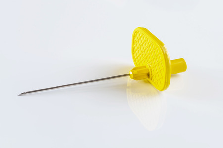 Disposable venipuncture cannula on reflective white background.の写真素材