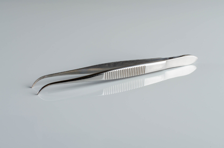 Medical tweezers on reflective background.の写真素材