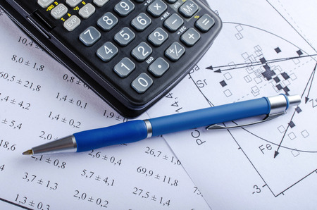 Calculator with pen on paper representing numbers and scientific figure.