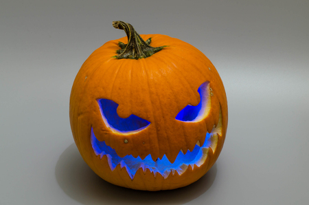 Jack-o 'lantern with blue light on gray backround. Halloween background.の写真素材