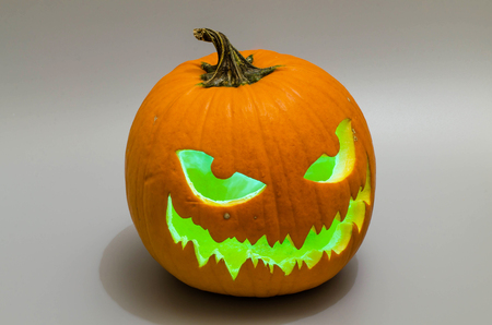 Jack-o 'lantern with green light on gray backround. Halloween background.の写真素材