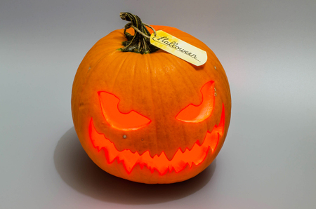 Jack o lantern with red light and label on gray background. Halloween decor.の写真素材