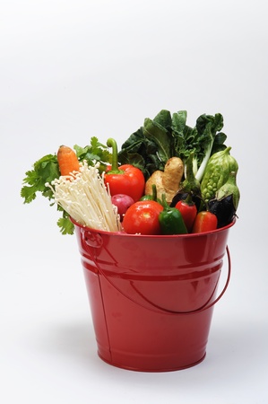 Red bucket of vegetables.の写真素材