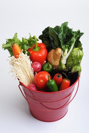 Red bucket of vegetables.の写真素材