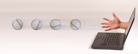 Baseball coming out of computer screen.の写真素材