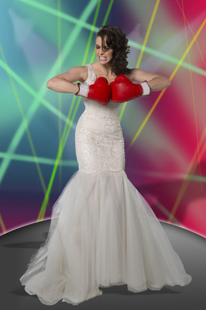 Young girl in boxing gloves trying to look strong.の写真素材