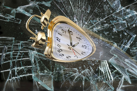 Alarm clock flying through broken window.