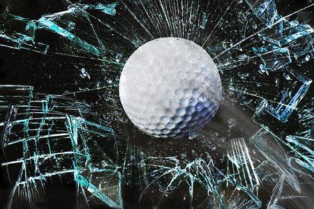 Fast golf ball through broken window.の写真素材