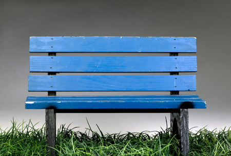 Old blue park bench on green grass.の写真素材