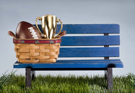 Blue park bench with handmade basket and football..の写真素材