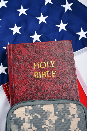 Soldier bible in camouflage bag on flag with room for your type.の写真素材