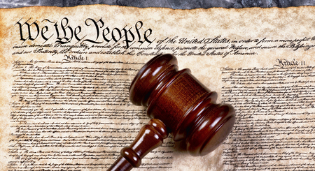 Wooden gavel on top of American Bill of Rights document, We the People.