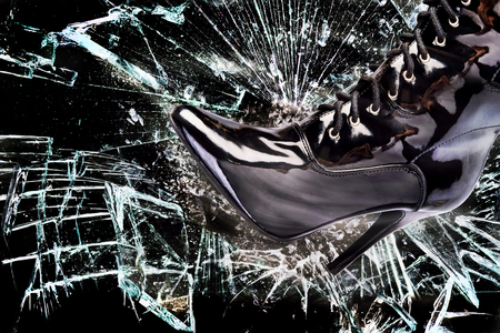 Ladies boot breaking glass window pane.の写真素材