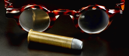 Spectacles and brass bullet.