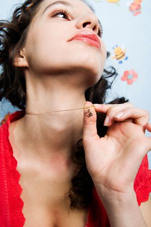 Girl holding heart-shaped pendant thinking about her loveの写真素材
