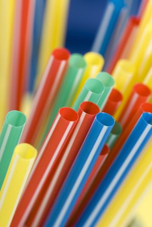 Bunch of colorful drinking straws on a bright backgroundの写真素材