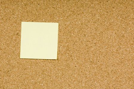 Blank sticky note on a cork bulletin boardの写真素材