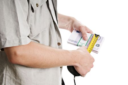 Man's hands measuring stack of 500 euro billsの写真素材
